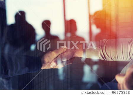 Handshaking business person in office. concept of teamwork and partnership. double exposure Handshaking business person in office. concept of teamwork and partnership. double exposure 96275538