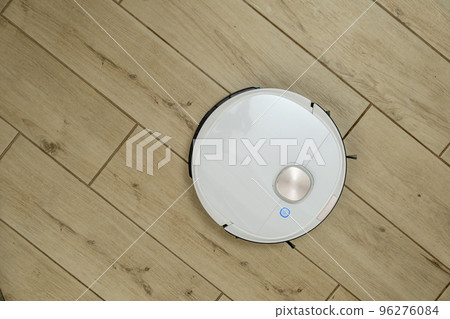 Robotic vacuum cleaner cleans wood-patterned tiled floor 96276084