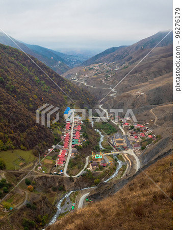 Small village in a gorge of high mountains. Erzi is a village in the Dzheyrakh district of Ingushetia. Vertical view of the village from a high autumn hill. Small village in a gorge of high mountains. Erzi is a village in the Dzheyrakh district of Ingushetia. Vertical view of the village from a high autumn hill. 96276179