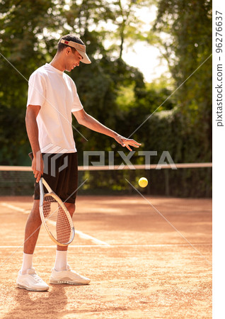 Young tennis player having a workout at the tennis courts 96276637