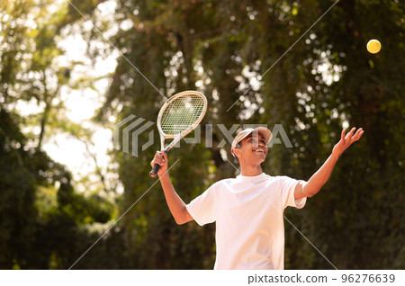 Young man in sportswear with a racket at the tennis court 96276639