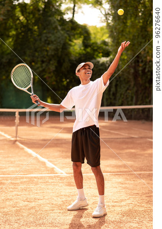 Young man in sportswear with a racket at the tennis court 96276640