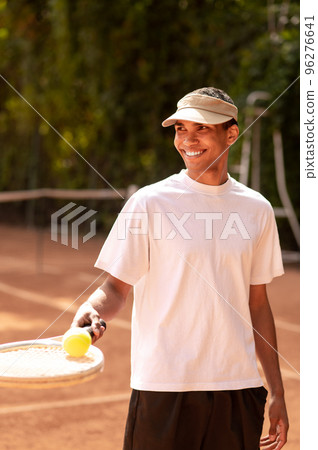 Young man in sportswear with a racket at the tennis court Young man in sportswear with a racket at the tennis court 96276641