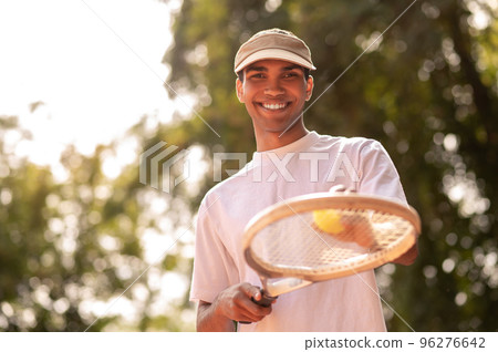 Young man in sportswear with a racket at the tennis court Young man in sportswear with a racket at the tennis court 96276642