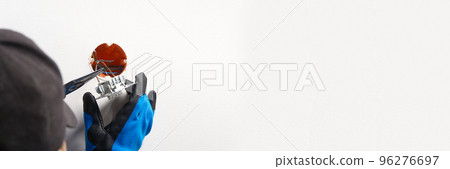 electrician installing light switch on painted wall with screwdriver. Man installing light switch after home renovation. electrician installing light switch on painted wall with screwdriver. Man installing light switch after home renovation. 96276697