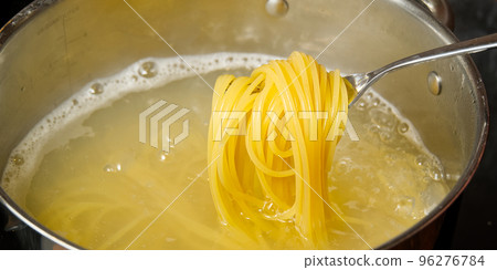 boiling pasta spaghetti in pot. penne rigate pasta- Cooking pasta in boiling water. 96276784
