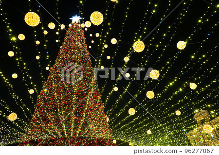 Christmas tree glows on the square in the city. Evening, night illumination Christmas tree glows on the square in the city. Evening, night illumination 96277067