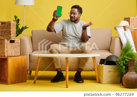 Portrait of happy excited man showing smartphone with green screen, new app concept 96277289