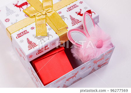 Christmas banner, holiday box with toys on a white background. Bunny ears out of the box. Christmas banner, holiday box with toys on a white background. Bunny ears out of the box. 96277569