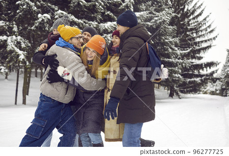 Happy friends in outerwear relax on weekend on winter holidays Happy friends in outerwear relax on weekend on winter holidays 96277725