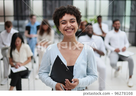 Happy businesswoman talking to her colleagues on seminar in the office. Happy businesswoman talking to her colleagues on seminar in the office. 96278108