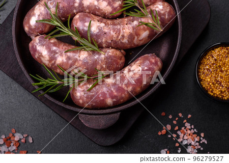 Raw pork sausages grill with spices and herbs on a dark concrete table 96279527