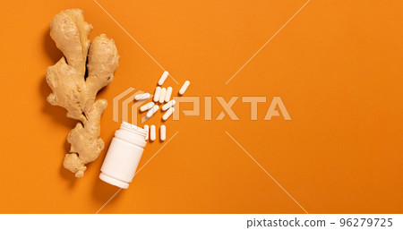 Fresh ginger root jar with vitamin pills orange background, medicine, nutritional supplements Fresh ginger root jar with vitamin pills orange background, medicine, nutritional supplements 96279725