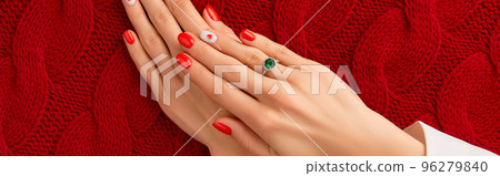 Manicured womans hands on knitted wool red fabric. Fashionable valentines day nail design 96279840