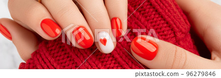 Manicured womans hands in warm wool red sweater. Fashionable valentines day nail design 96279846