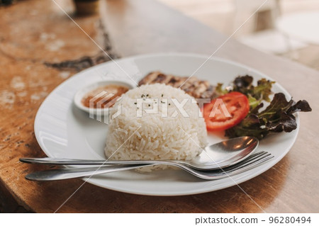 Baked chicken with white rice served on the table. 96280494
