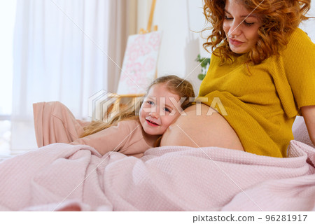 Pregnant mom plays with her daughter. Concept of family, joy and pregnancy 96281917