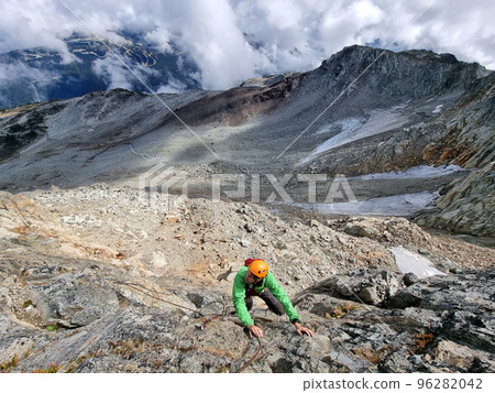 Via Ferrata mountain hike climber man climbing on steep rock in Whistler, BC, Canada travel destination. Summer adventure Via Ferrata mountain hike climber man climbing on steep rock in Whistler, BC, Canada travel destination. Summer adventure 96282042