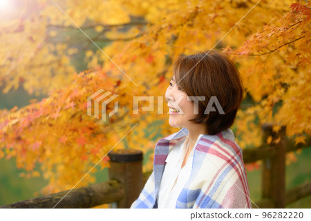 Middle-aged woman enjoying the autumn season Middle-aged woman enjoying the autumn season 96282220