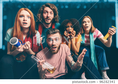 Boys and girls, behind a screen, look together a TV show at home 96282341
