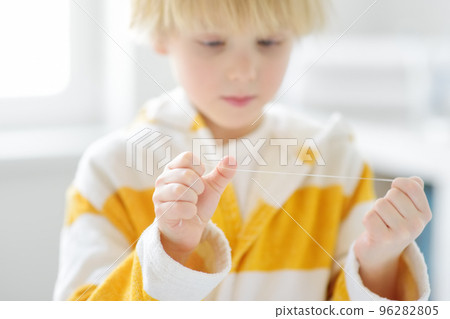 Preschooler boy cleaned teeth with dental floss and then is brushing his teeth with toothbrush carefully. Learning children proper oral hygiene. Dental medicine and healthcare of kids 96282805