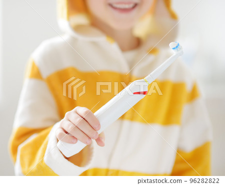 Child brushing teeth. Preschooler boy using electric toothbrush and toothpaste in bathroom during morning routine. Baby learning brush tooth. Equipments for kids dental and oral hygiene. 96282822