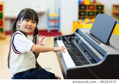 Elementary school students practicing the piano 96283470
