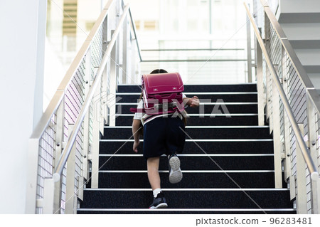 背著書包爬樓梯的小學生 96283481