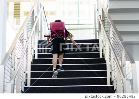背著書包爬樓梯的小學生 96283482