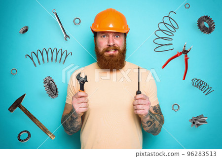 Confused man with screwdriver and spanners. worried and uncertain expression. cyan background Confused man with screwdriver and spanners. worried and uncertain expression. cyan background 96283513