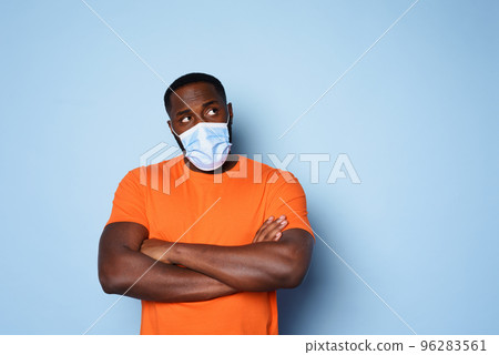 Man with face mask has a lot of questions and doubts about covid 19. cyan background 96283561