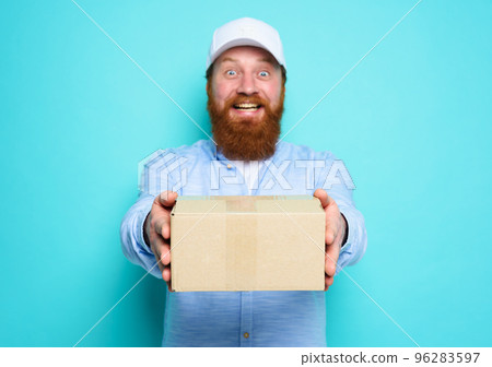 Courier is happy to deliver a carton box. Emotional expression. Cyan background Courier is happy to deliver a carton box. Emotional expression. Cyan background 96283597