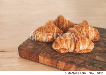 Croissants fresh baked pastries from french bakery. 4 viennoiseries on wooden board. Breakfast food from France baking culture. Flaky warm croissant Croissants fresh baked pastries from french bakery. 4 viennoiseries on wooden board. Breakfast food from France baking culture. Flaky warm croissant 96283894
