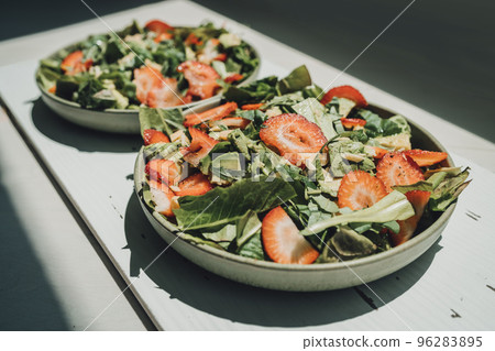 Healthy food at home. Fresh salads lunch meal two plates of kale lettuce and strawberries 96283895