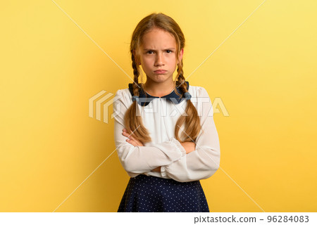Young girl is unhappy and angry about something. yellow background Young girl is unhappy and angry about something. yellow background 96284083