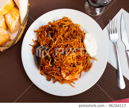 Dish of Valencian cuisine Fideua with seafood and noodles Dish of Valencian cuisine Fideua with seafood and noodles 96284217
