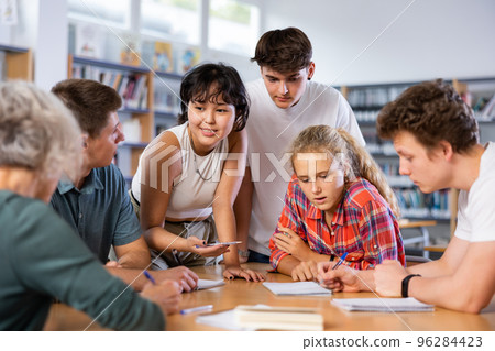 Team of diligent schoolkids during classes in library 96284423