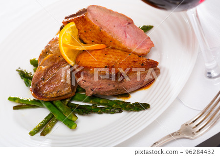 Fried duck breast with asparagus and grilled onions 96284432