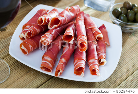 Traditional Spanish meal - rolls of iberian jamon served at plate Traditional Spanish meal - rolls of iberian jamon served at plate 96284476