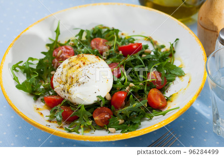 Salad with burrata cheese, pine nuts, cherry tomatoes and arugula Salad with burrata cheese, pine nuts, cherry tomatoes and arugula 96284499