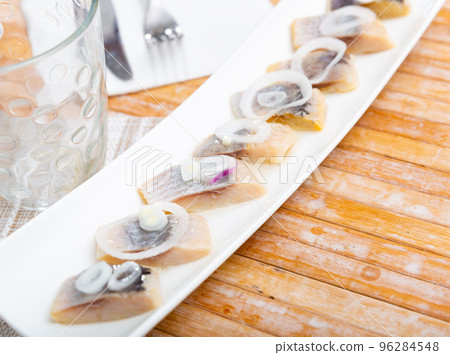 Salted pickled herring fish served on a ceramic plate Salted pickled herring fish served on a ceramic plate 96284548