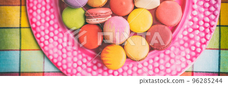 Many macarons at bakery in gift box. Panoramic banner of french sweet desserts top view Many macarons at bakery in gift box. Panoramic banner of french sweet desserts top view 96285244