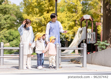 Nursery teacher and kindergarten children walking 96287442