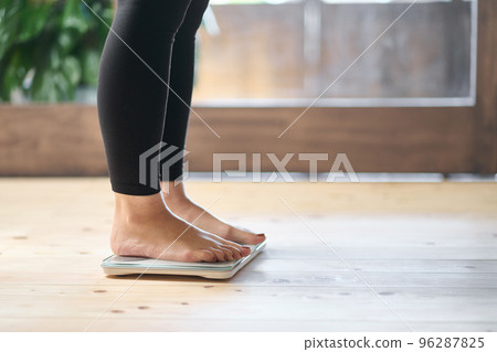 Feet of an Asian woman on a weight scale 96287825