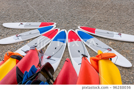 Sup board and kayaks rental place on the beach. Surfboards, many different surf boards on the beach, water sport, happy active summer vacation. Row of stand up paddle boards ready to rent. 96288036