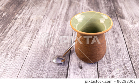 Clay mate calabash with bombilla on grey wood background 96288302