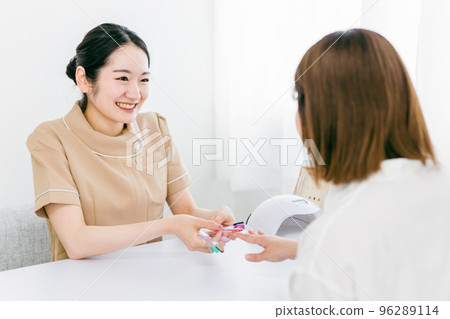 Manicurist and Asian woman doing personal color diagnosis at nail salon 96289114