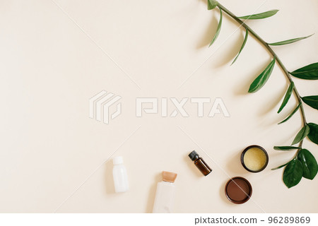 Natural organic cosmetics for body and face care on a beige background with space copying. Bottles of creams, a jar and a bottle of oil, a sprig of zamiokulkas. Top view Natural organic cosmetics for body and face care on a beige background with space copying. Bottles of creams, a jar and a bottle of oil, a sprig of zamiokulkas. Top view 96289869