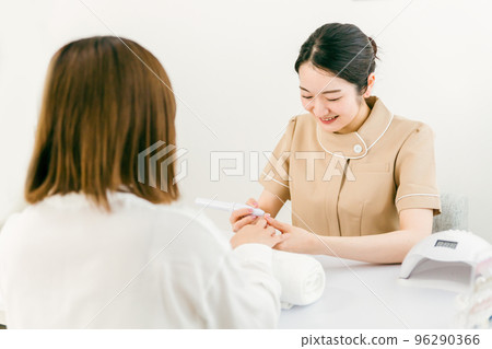 Manicurist and Asian woman doing preliminary preparation at nail salon 96290366