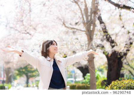 春天，櫻花盛開，微笑的女人將雙手伸向天空 96290748